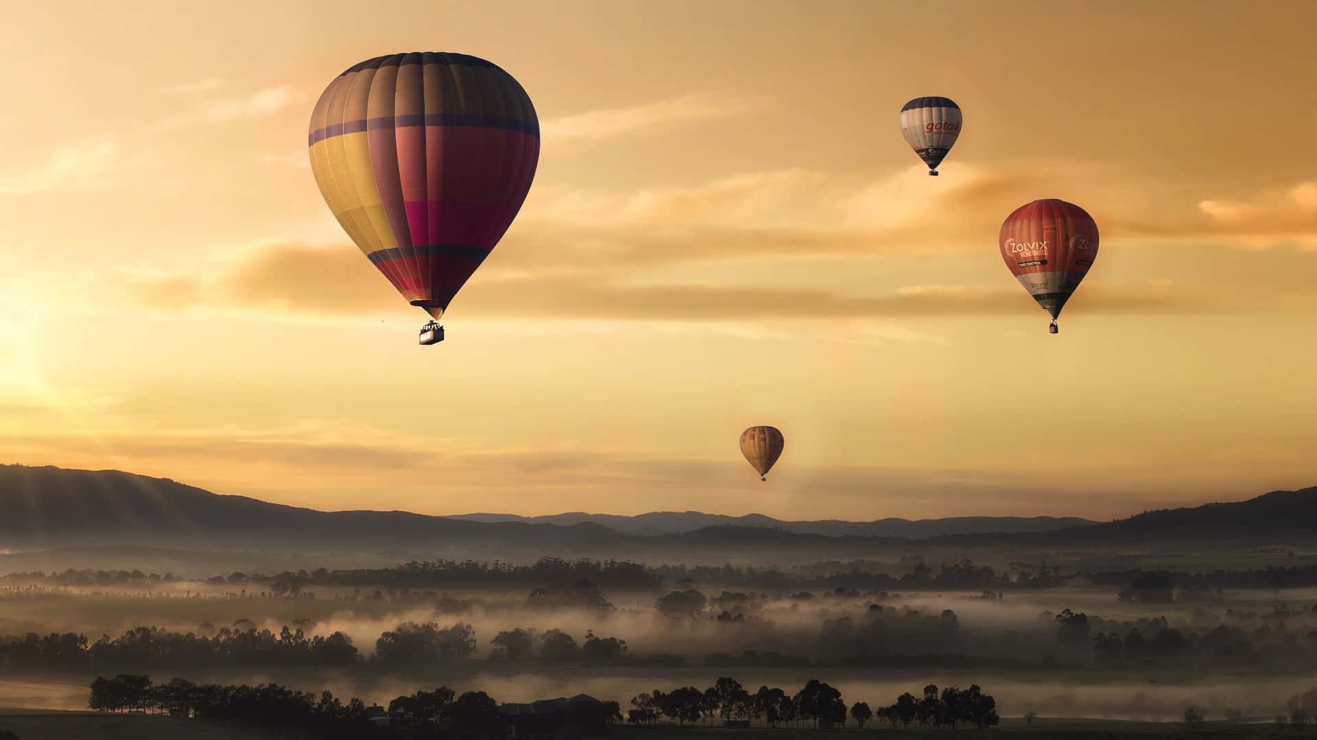 Hot Air Balloons Flying Over A Foggy Landscape Background