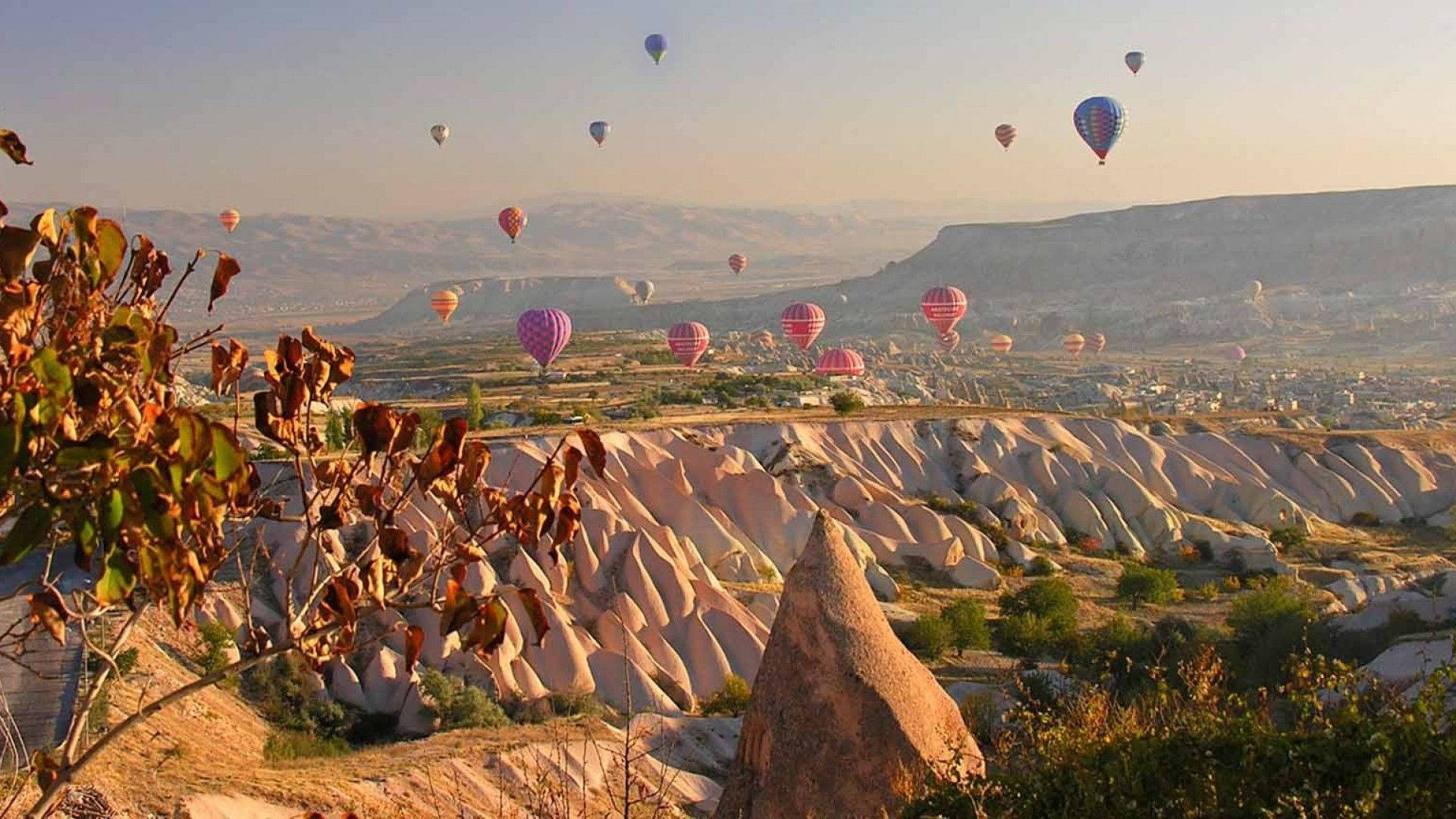 Hot Air Balloons Flying Over A Mountain Background