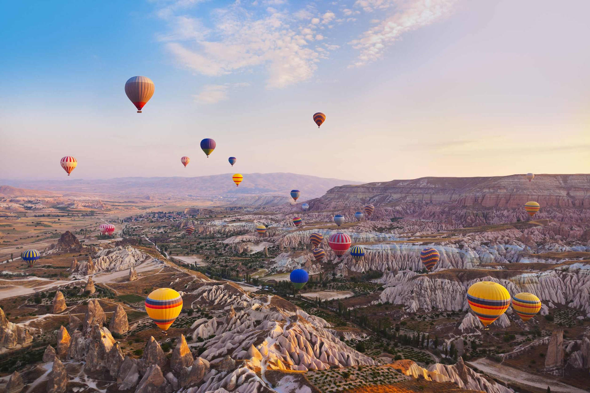 Hot Air Balloons Flying Over A Mountain Background