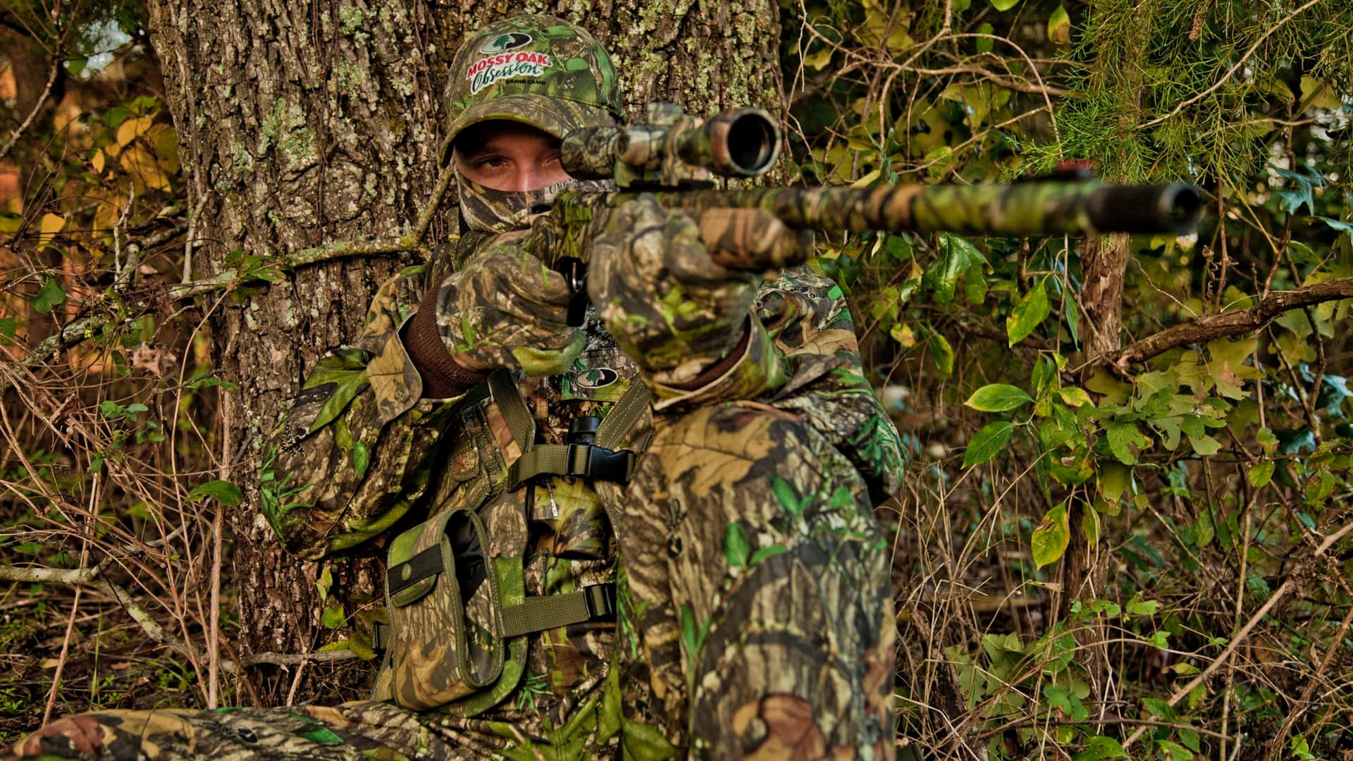 Hunting Camo Pointing A Gun Background