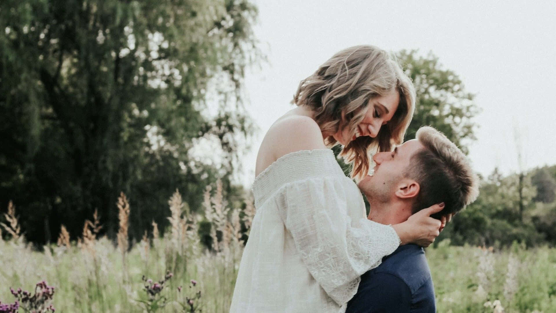 Husband And Wife Carry On Grass Field Background