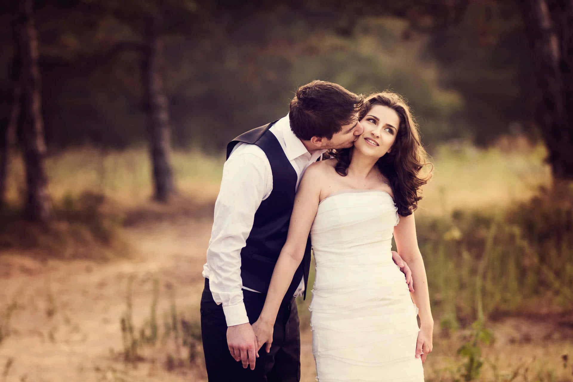 Husband And Wife Cheek Kiss On Grass Background