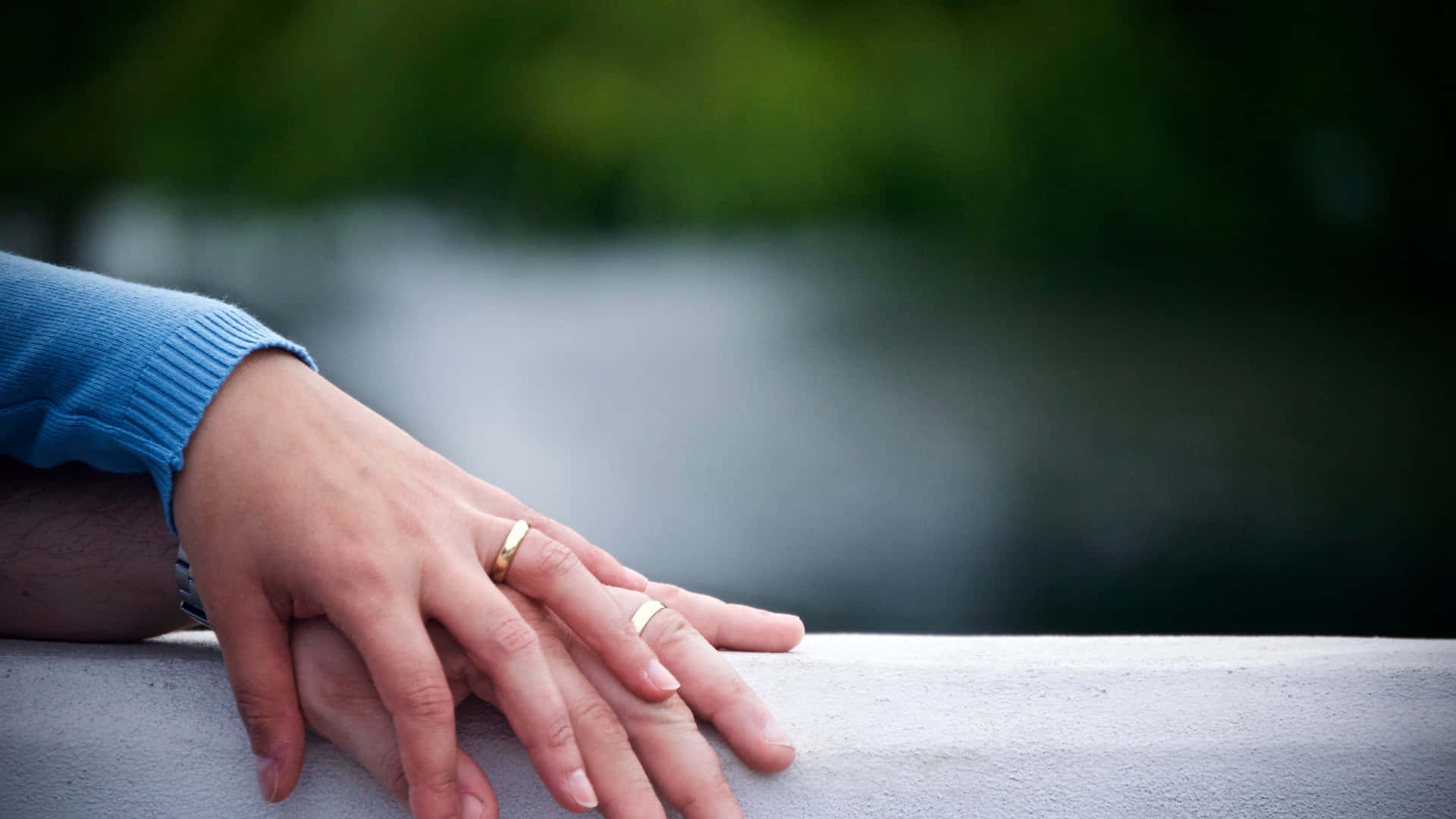 Husband And Wife Wedding Rings On Railing Background