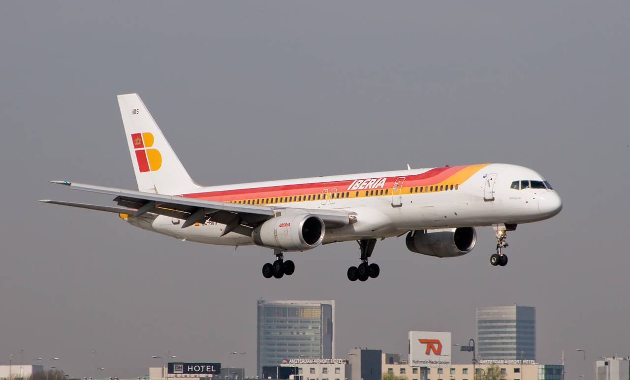 Iberia Airlines Airplane Above City Buildings Background