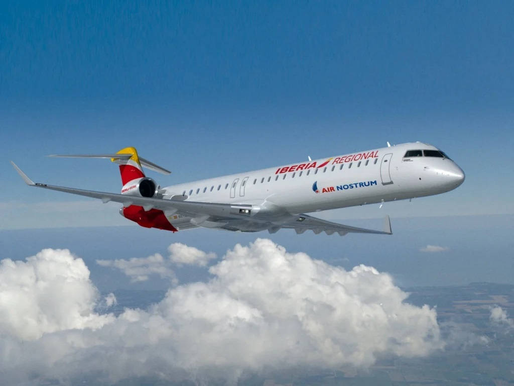 Iberia Airlines Airplane Above Sea Of Clouds Background