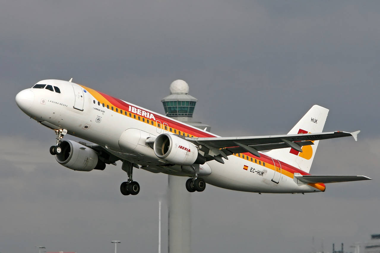 Iberia Airlines Airplane Flying By The Tower Background