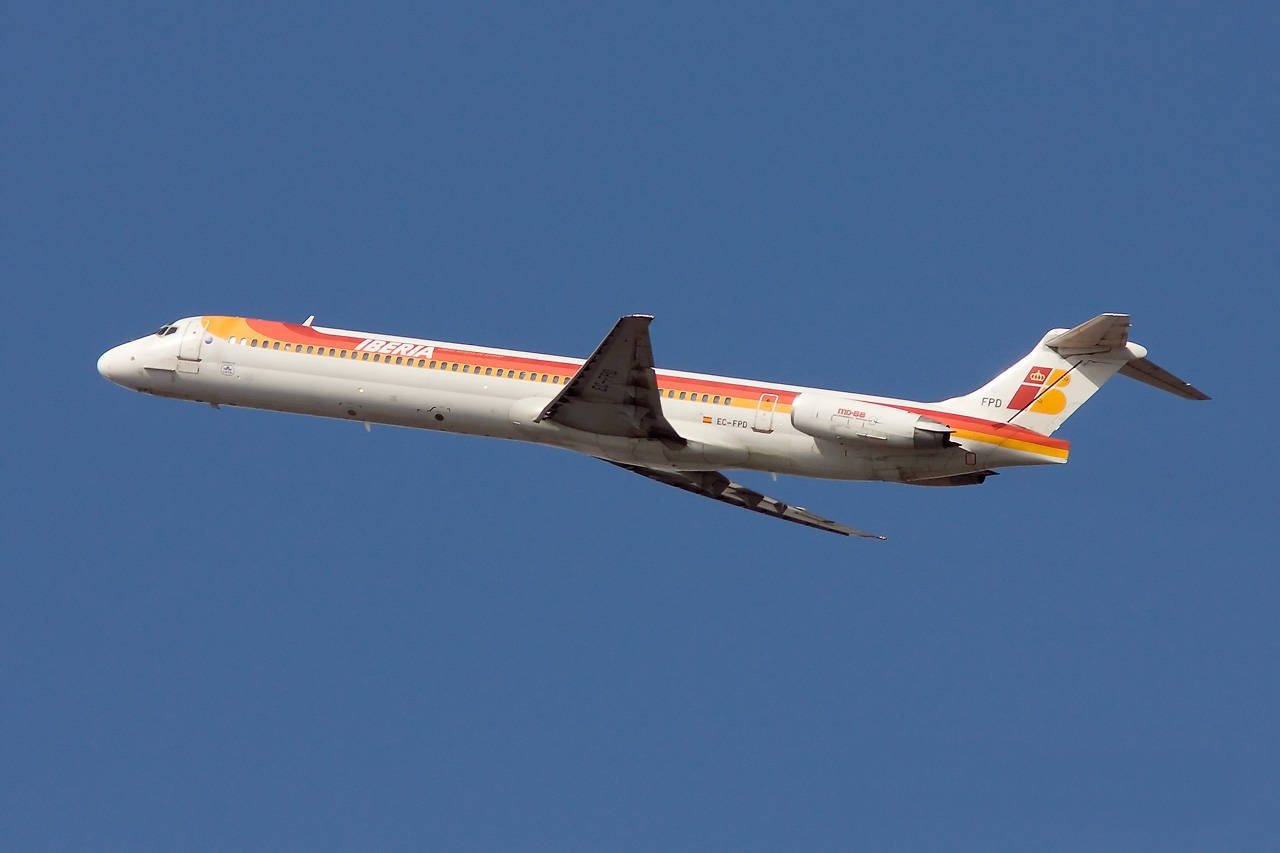 Iberia Airlines Airplane Flying In Plain Blue Sky Background