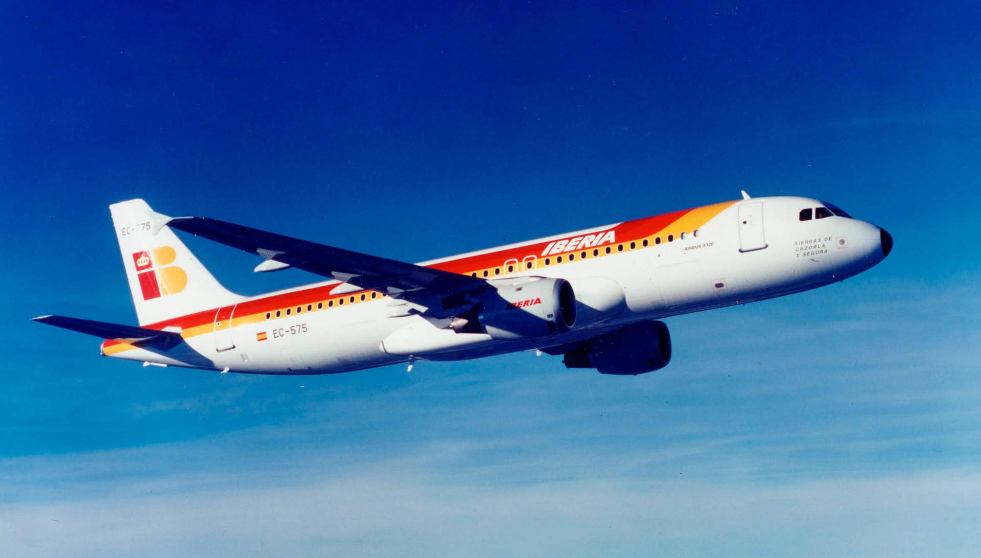 Iberia Airlines Airplane In The Blue Sky Background