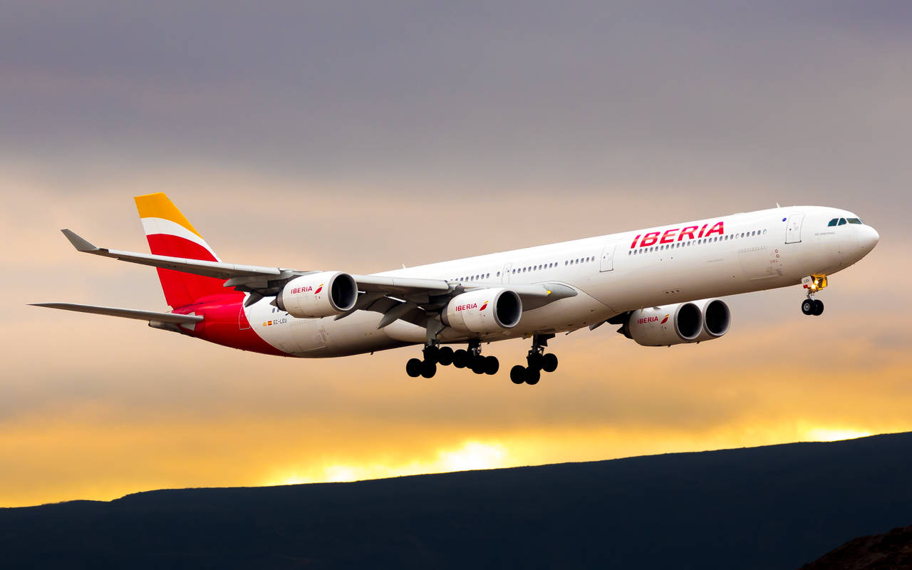 Iberia Airlines Airplane Takeoff At Sunset Background