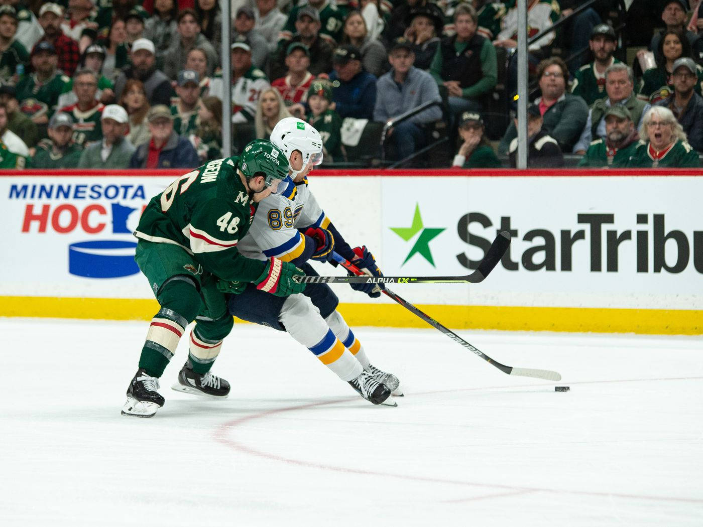 Ice Hockey Player Jared Spurgeon Fighting For Possession Background