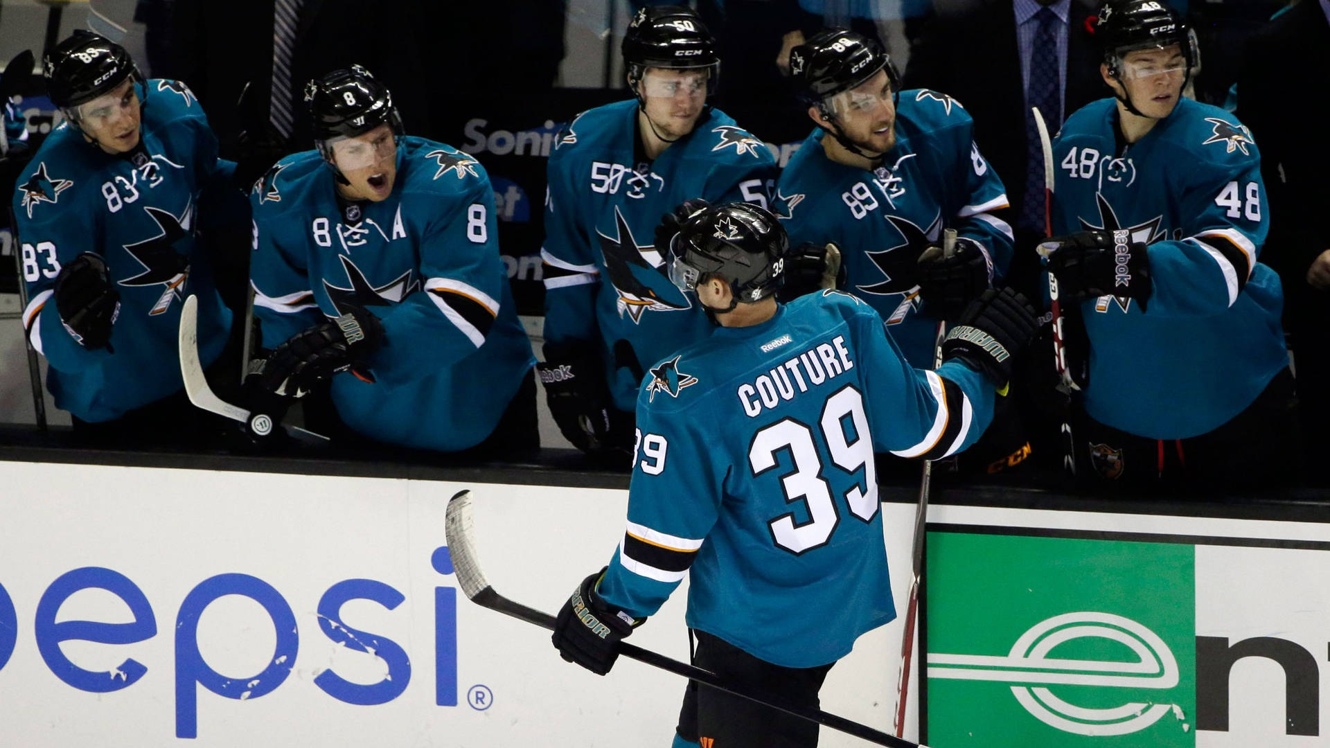 Ice Hockey Player Logan Couture Back Angle Shot And Teammates Background