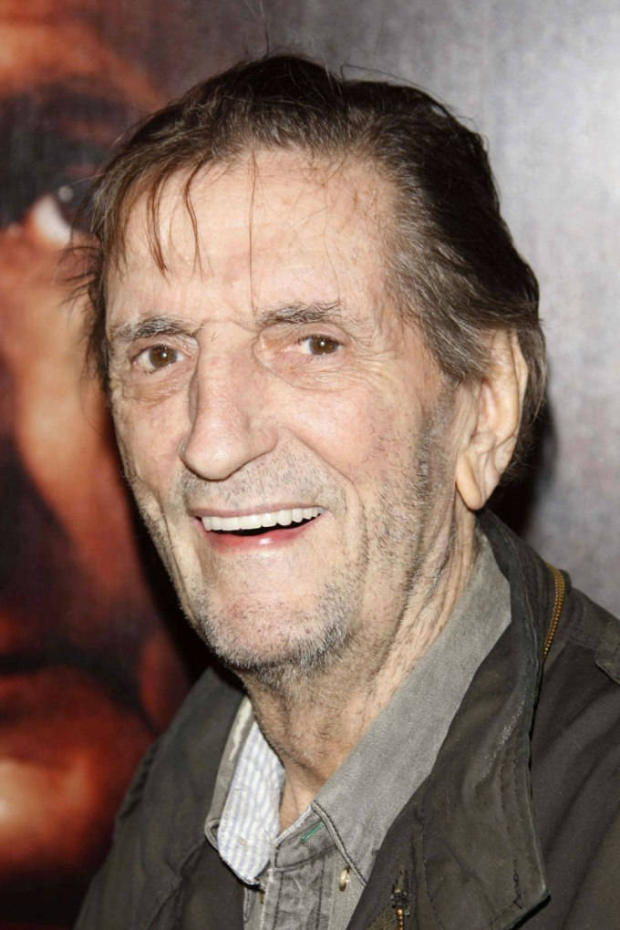 Iconic Actor Harry Dean Stanton In A Reflective Pose Background