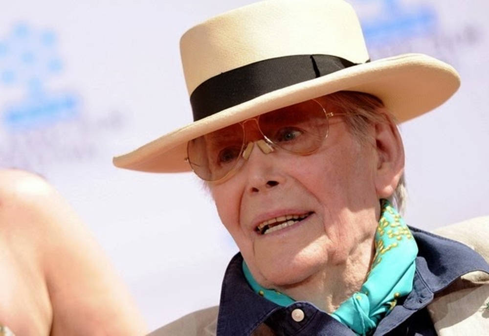 Iconic Actor Peter O'toole In A Classic Straw Boater Hat Background