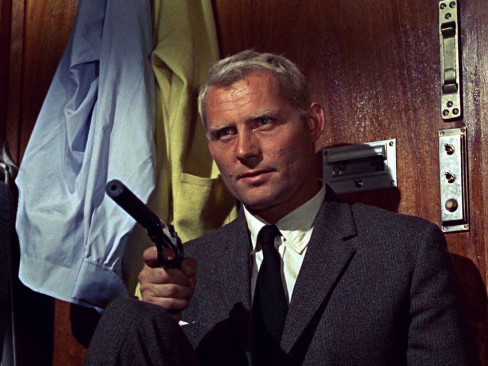 Iconic Actor Robert Shaw Brandishing A Gun Background