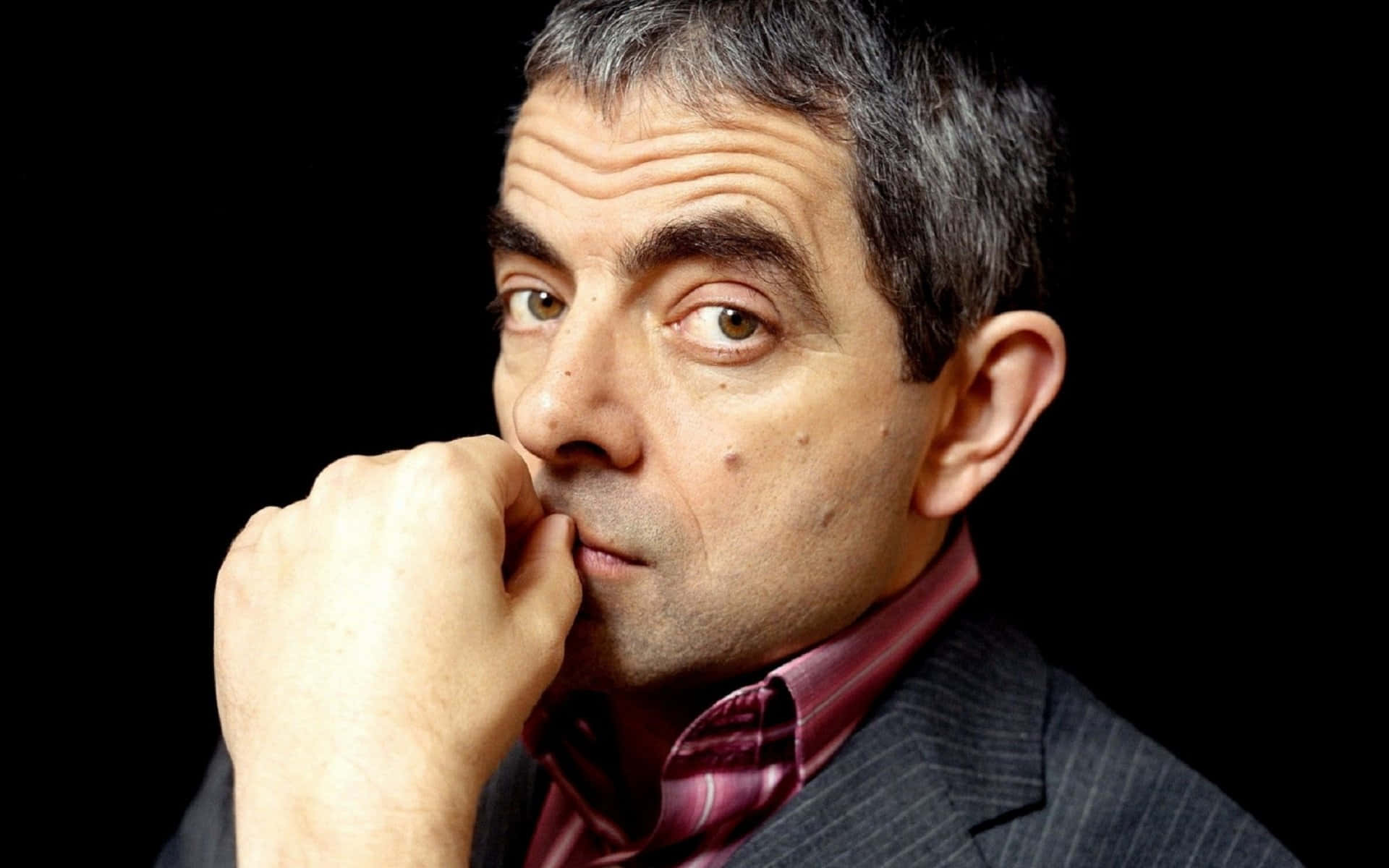 Iconic Actor Rowan Atkinson Posing On Red Background Background