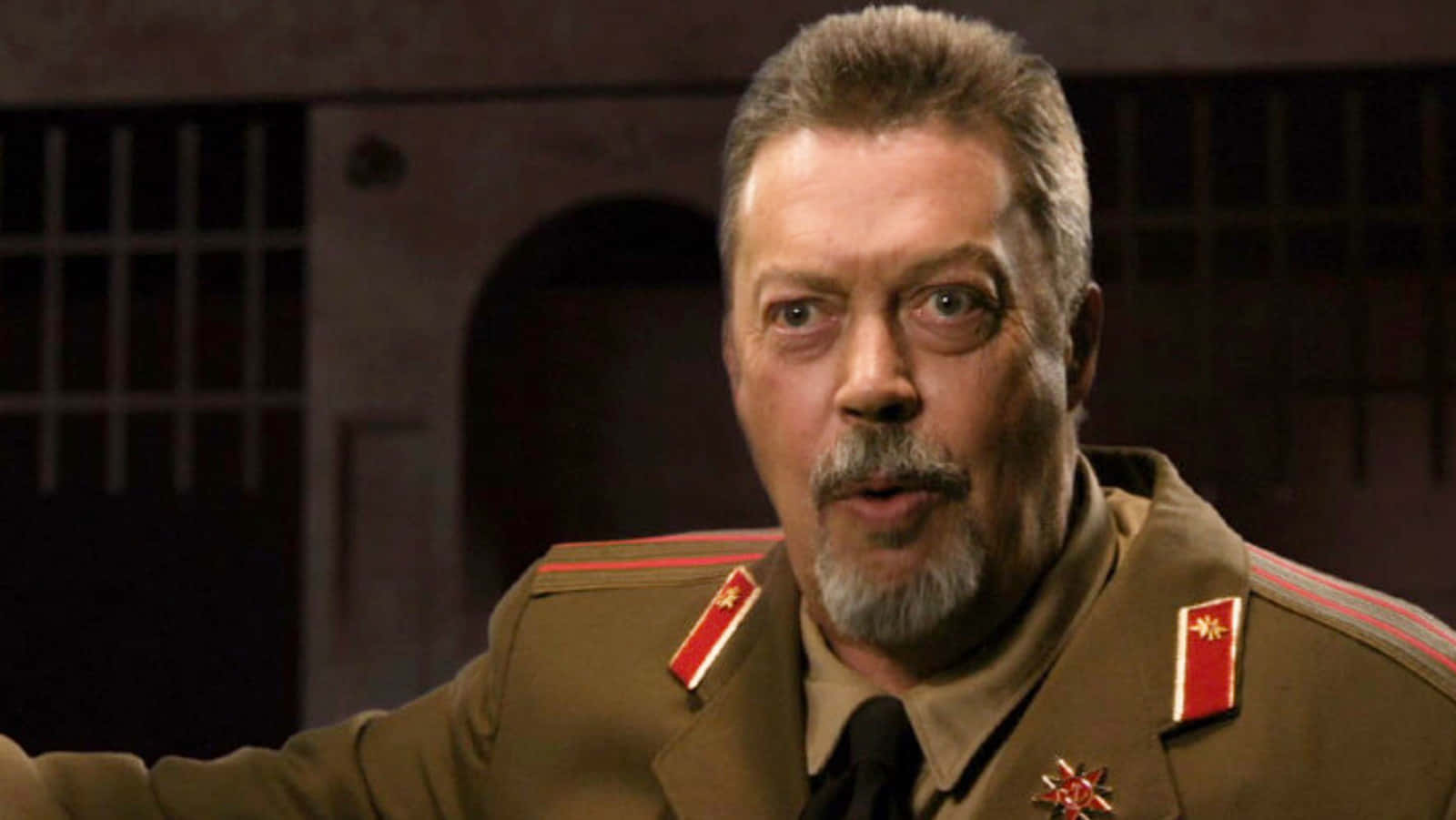 Iconic Actor Tim Curry Smiling During An Interview Background