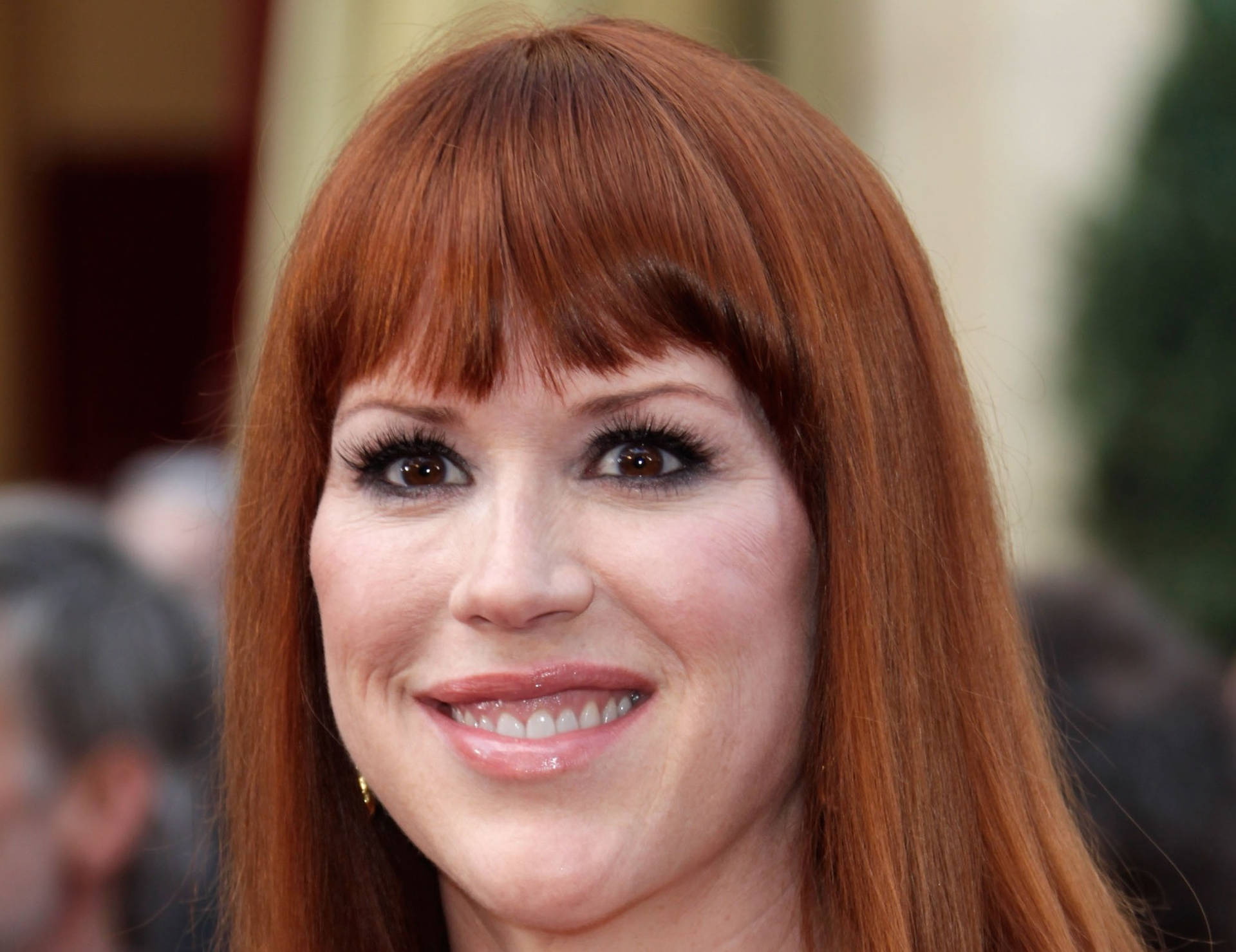 Iconic Actress Molly Ringwald Showcasing Her Signature Bangs Hairstyle Background