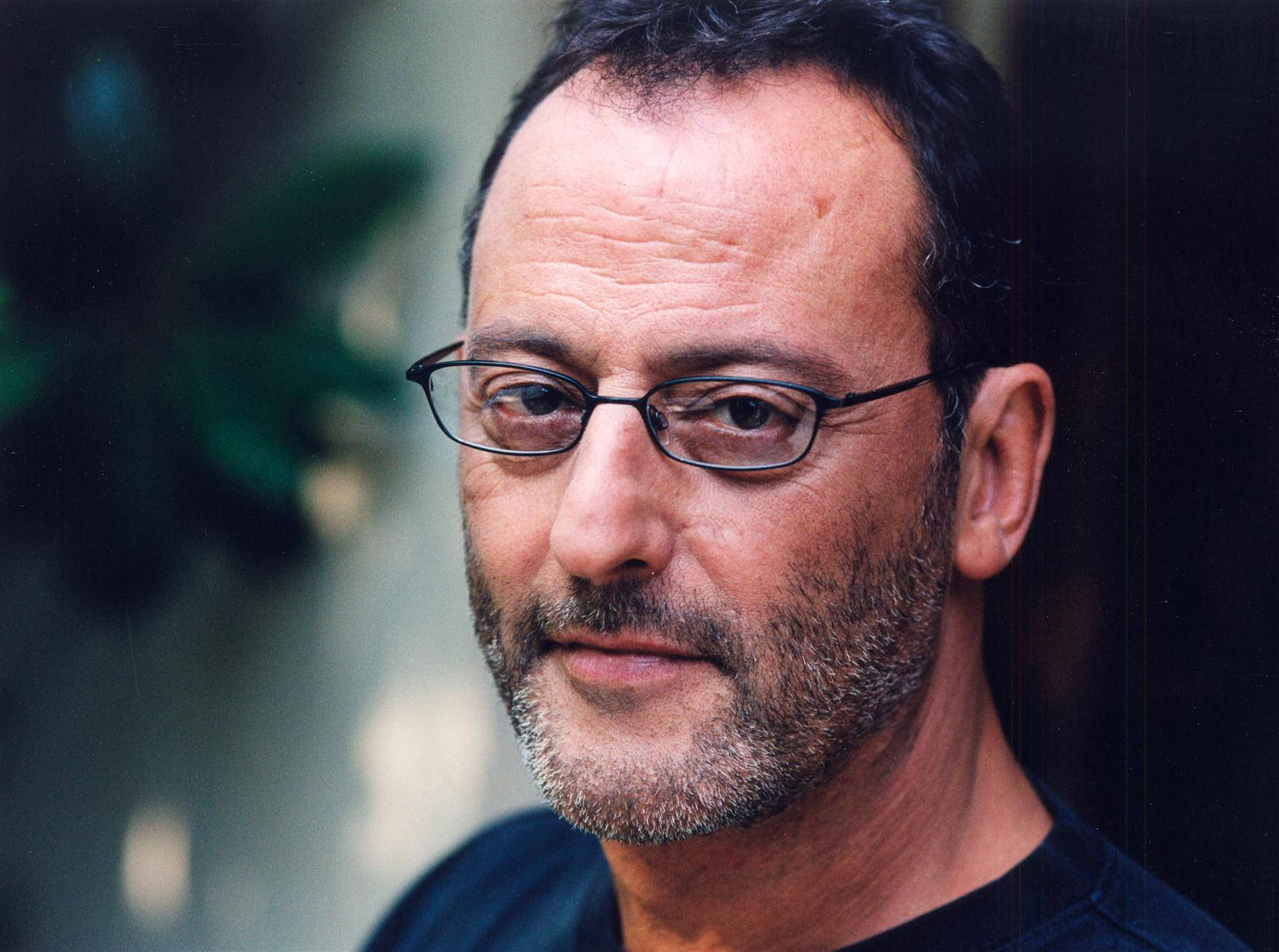 Iconic French Actor Jean Reno Poses Pensively. Background