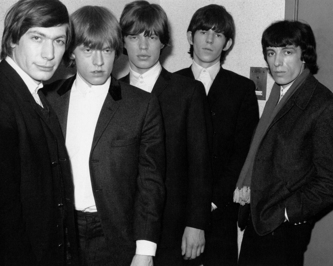 Iconic Rolling Stones In Black Suits Background
