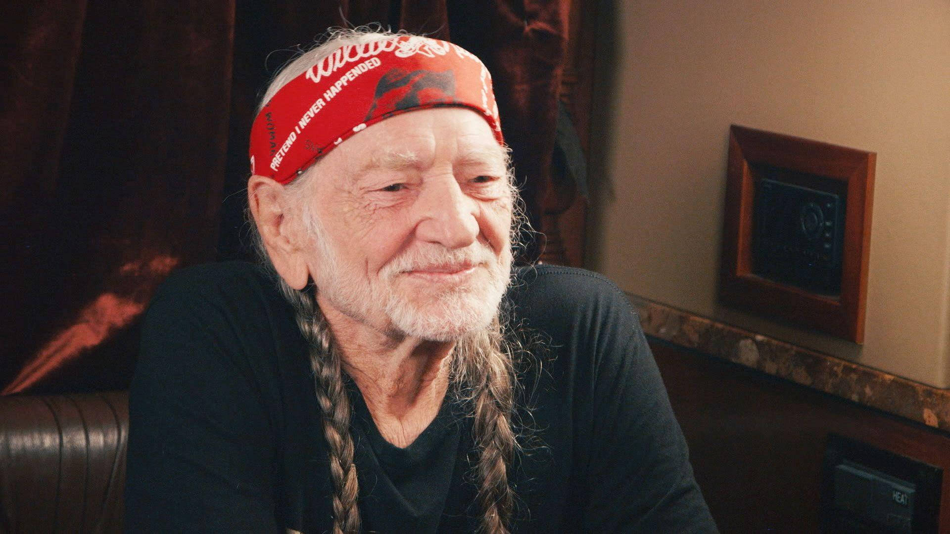 Iconic Singer Willie Nelson Posing With Braided Hair And Bandana