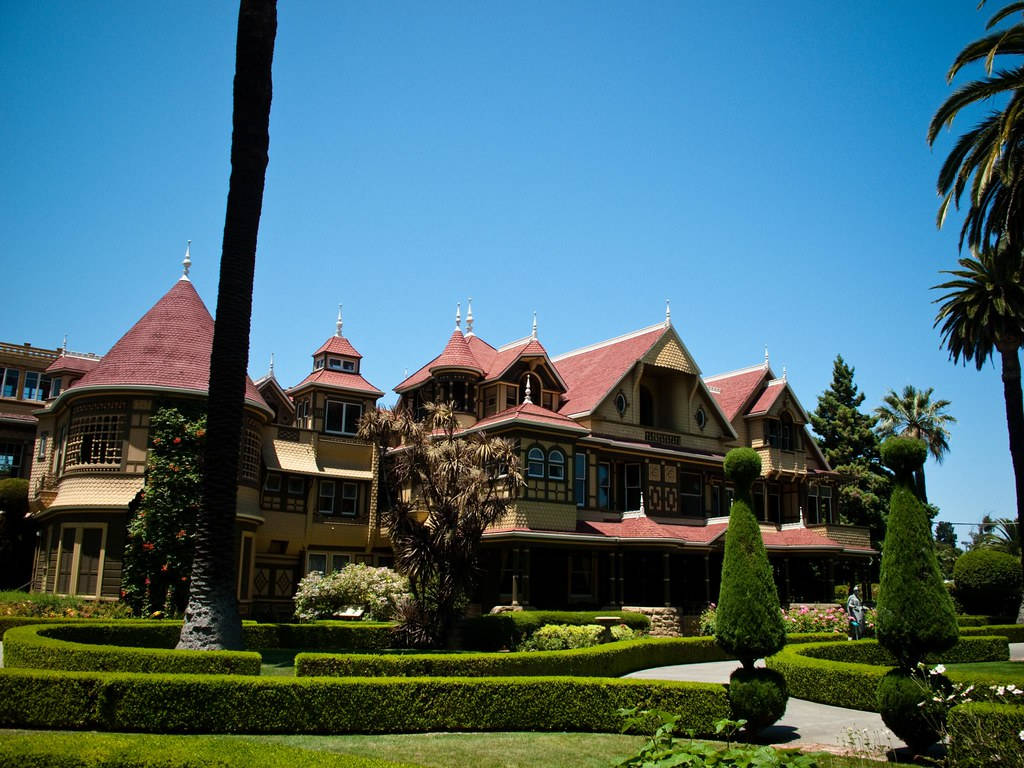 Iconic Winchester Mystery House With Beautiful Topiaries Background