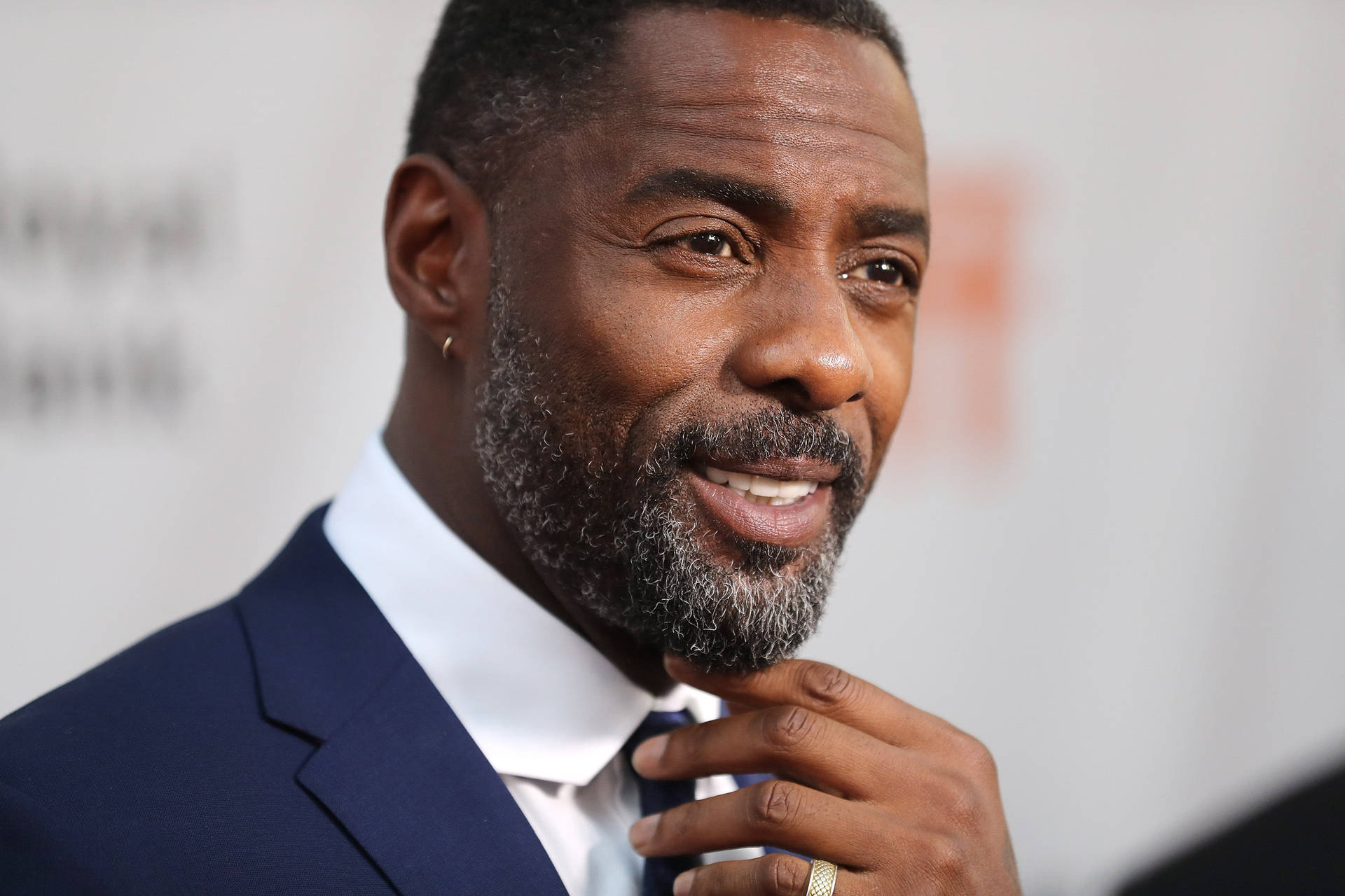 Idris Elba Touching Tie Of His Suit