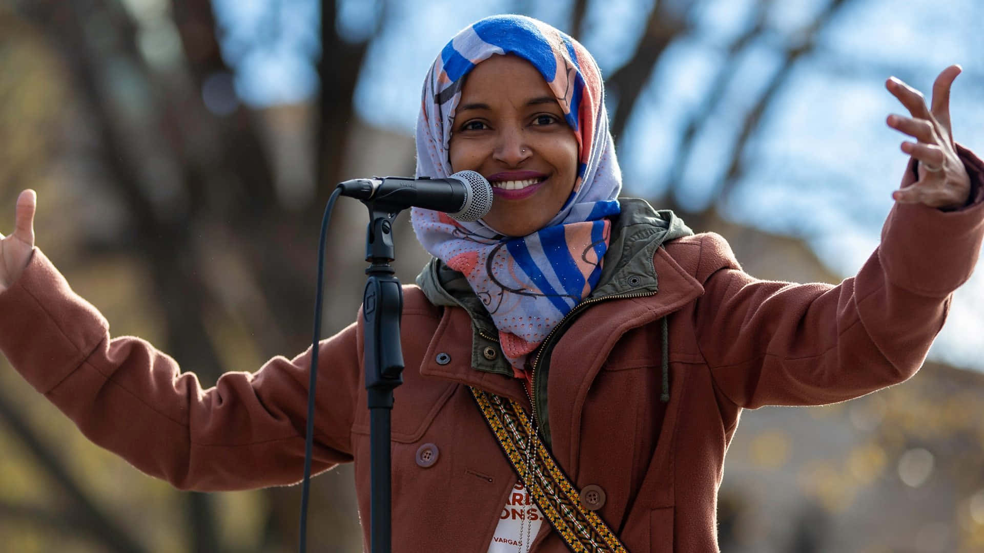 Ilhan Omar Arms Wide Open Background