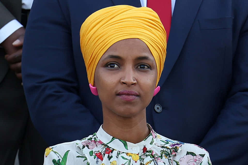 Ilhan Omar In A Yellow Hijab Background