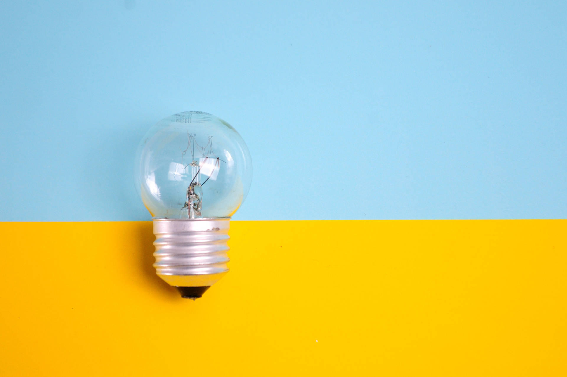 Illuminated Light Bulb Against Bright Background Background