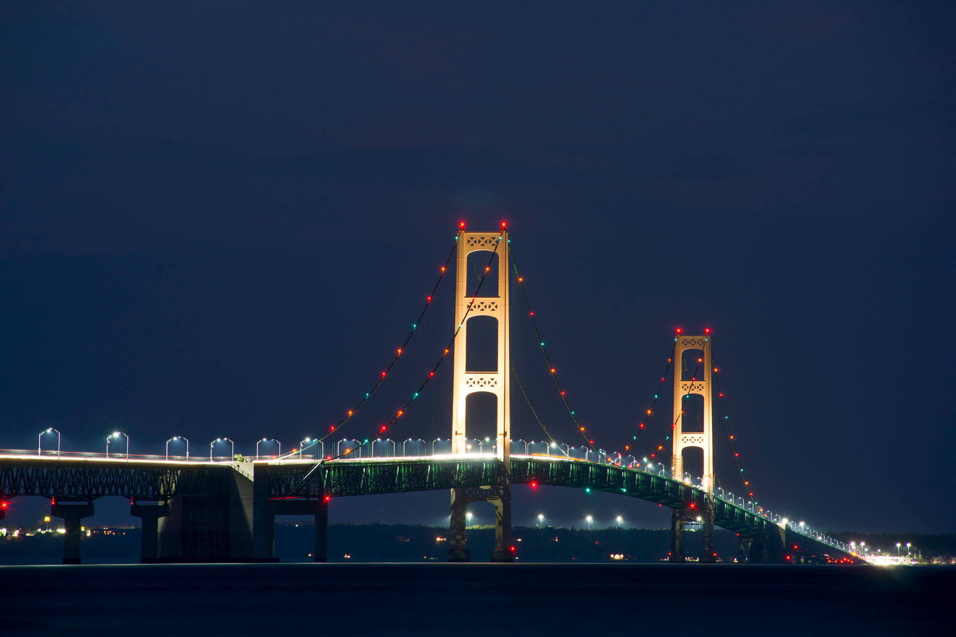 Illuminated Mackinac Bridge Under Starry Night Background