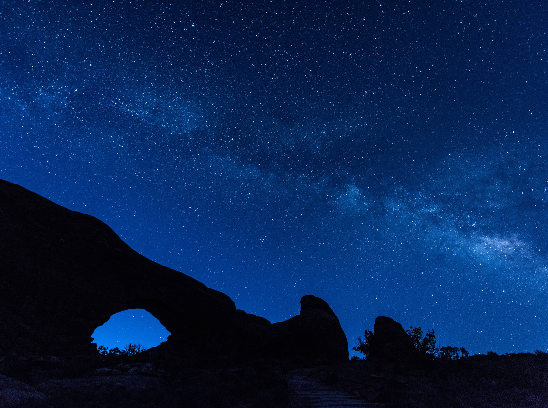 Illuminated Night Sky Above Arches National Park Background