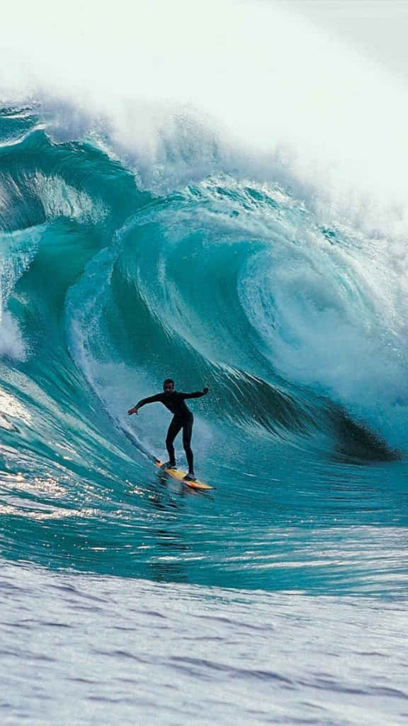 Image A Lone Surfer Catching Some Waves While Enjoying The Sunset With Their Iphone Background