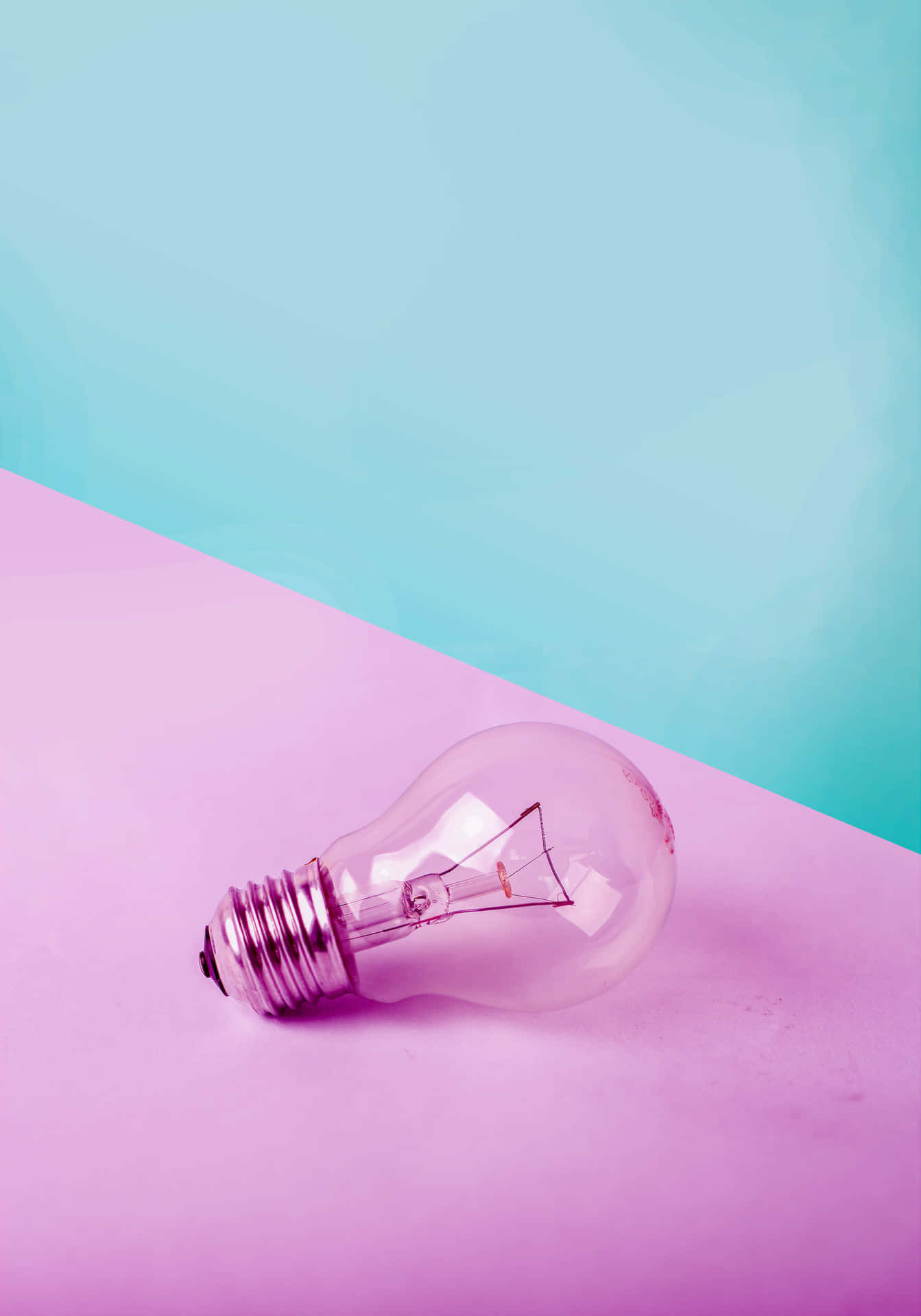 Incandescent Bulb On Pink Surface