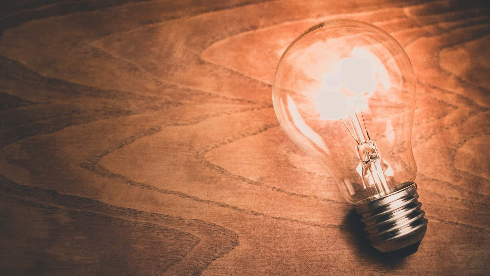 Incandescent Bulb On Wooden Surface Background