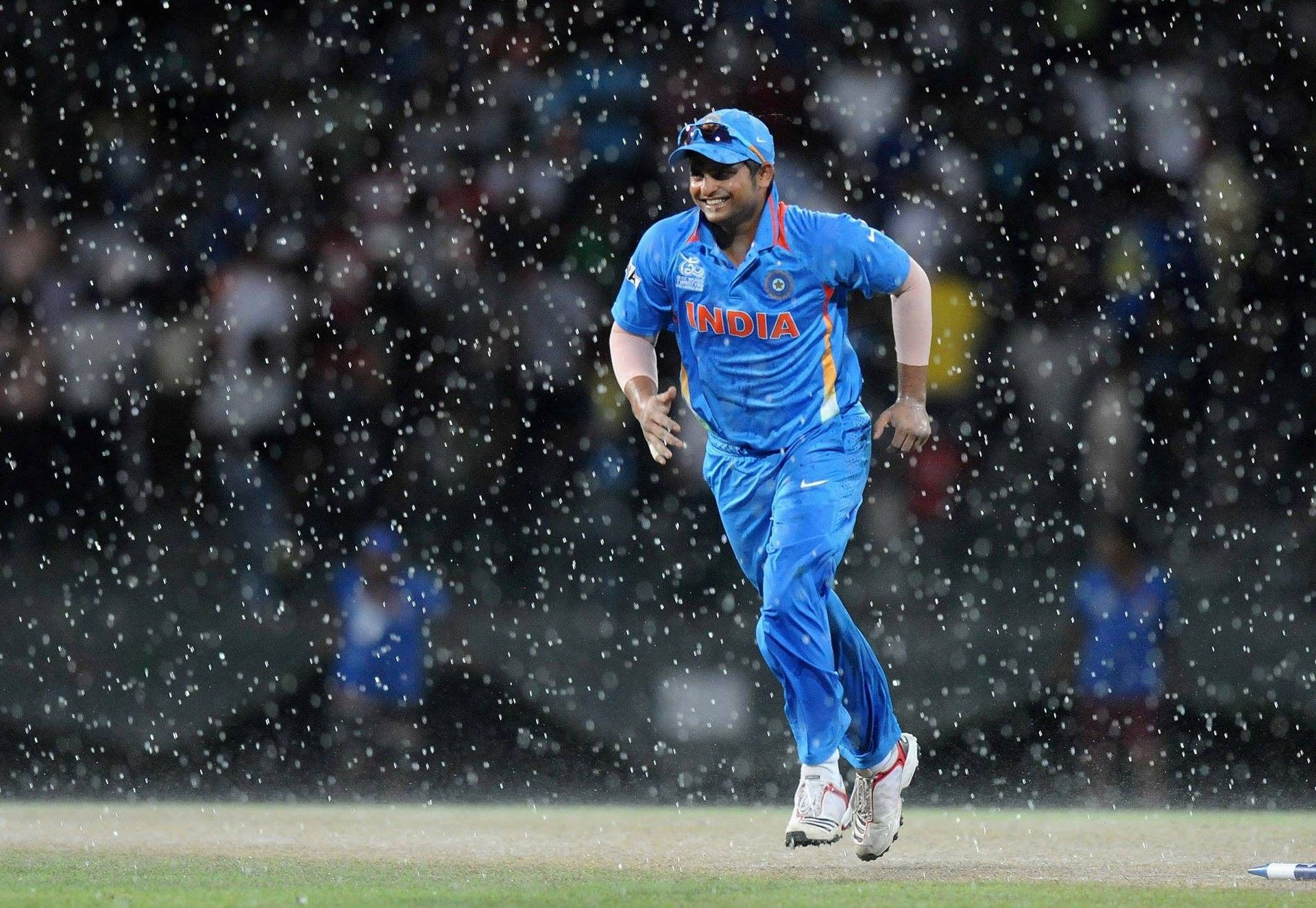 Indian Cricket Team Member Running In The Rain Background