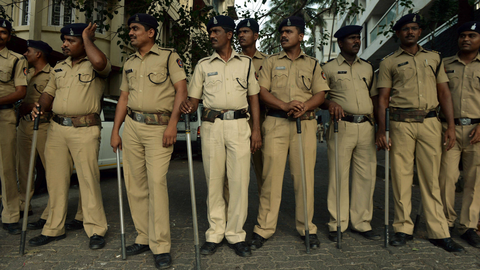 Indian Police Resting With Batons Background