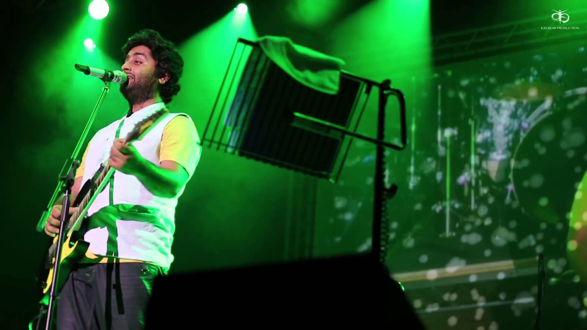 Indian Singer Arijit Singh On A Green Stage Background