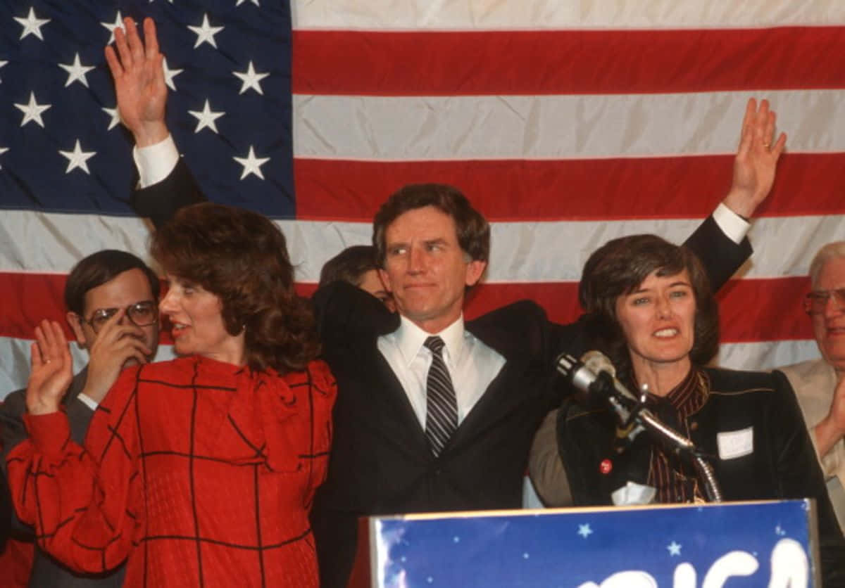 Influential Politician Gary Hart Waving To Crowd Background
