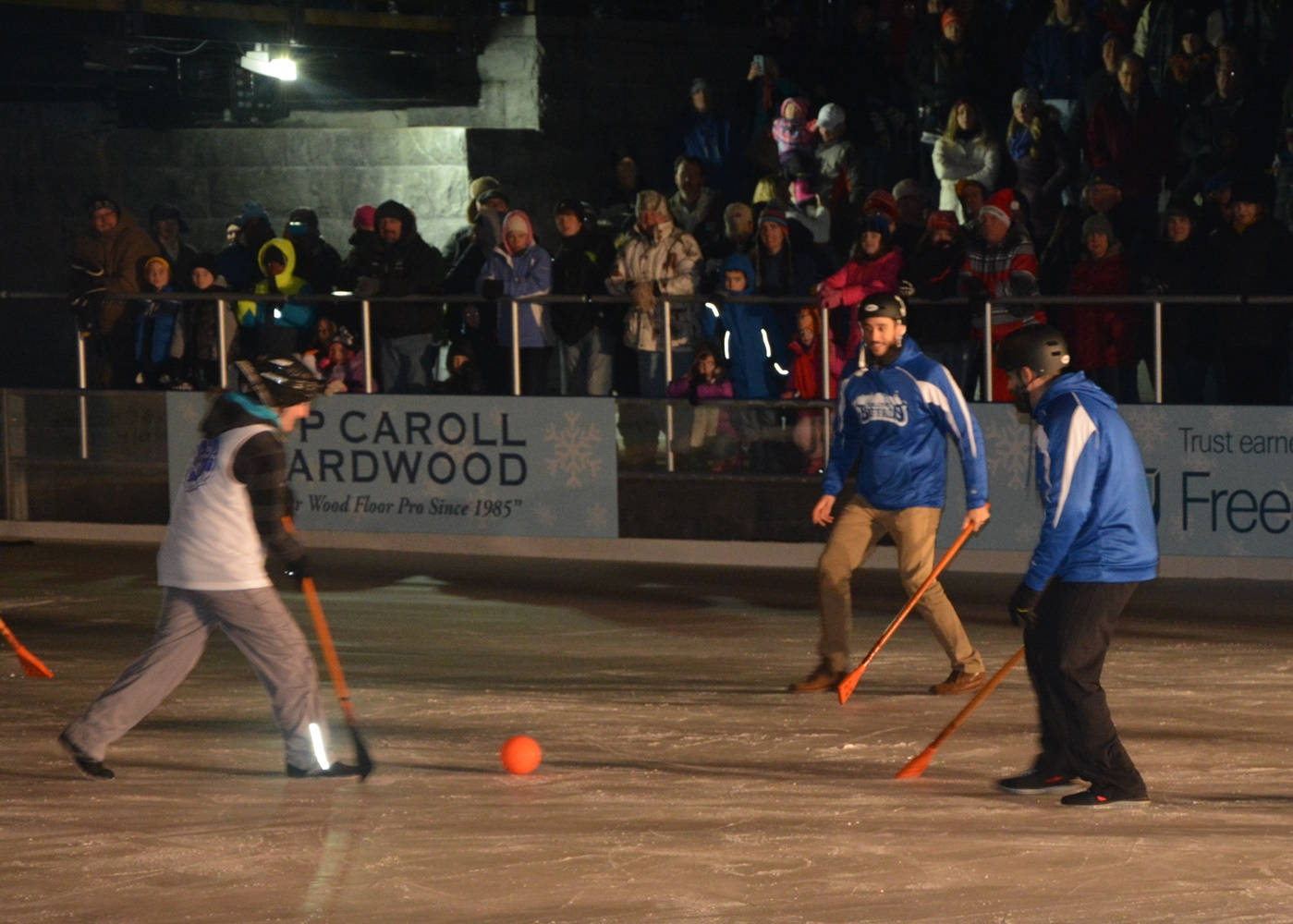 Intense Broomball Match With Blue And White Teams Background