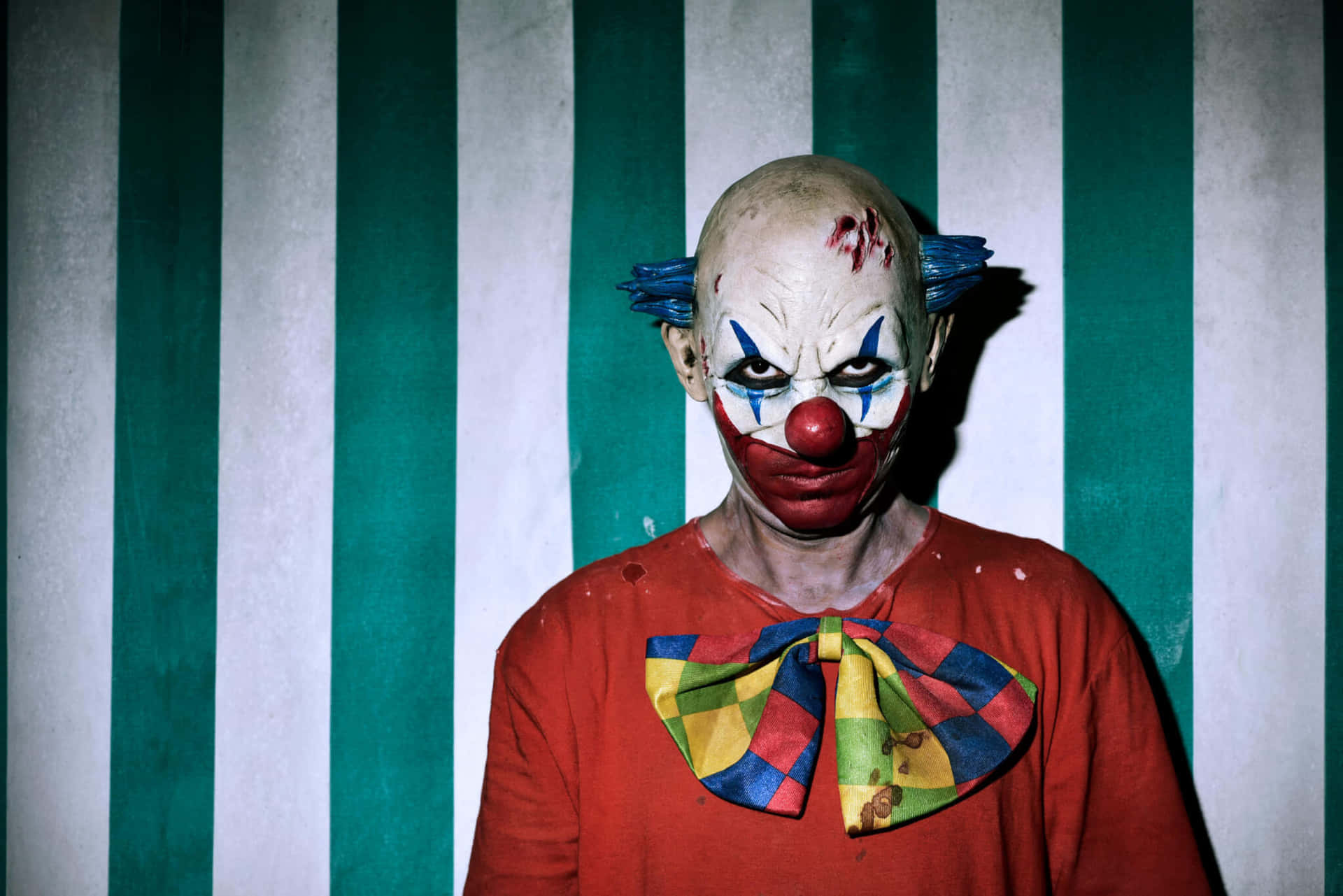 Intimidating_ Clown_ Against_ Striped_ Background.jpg Background