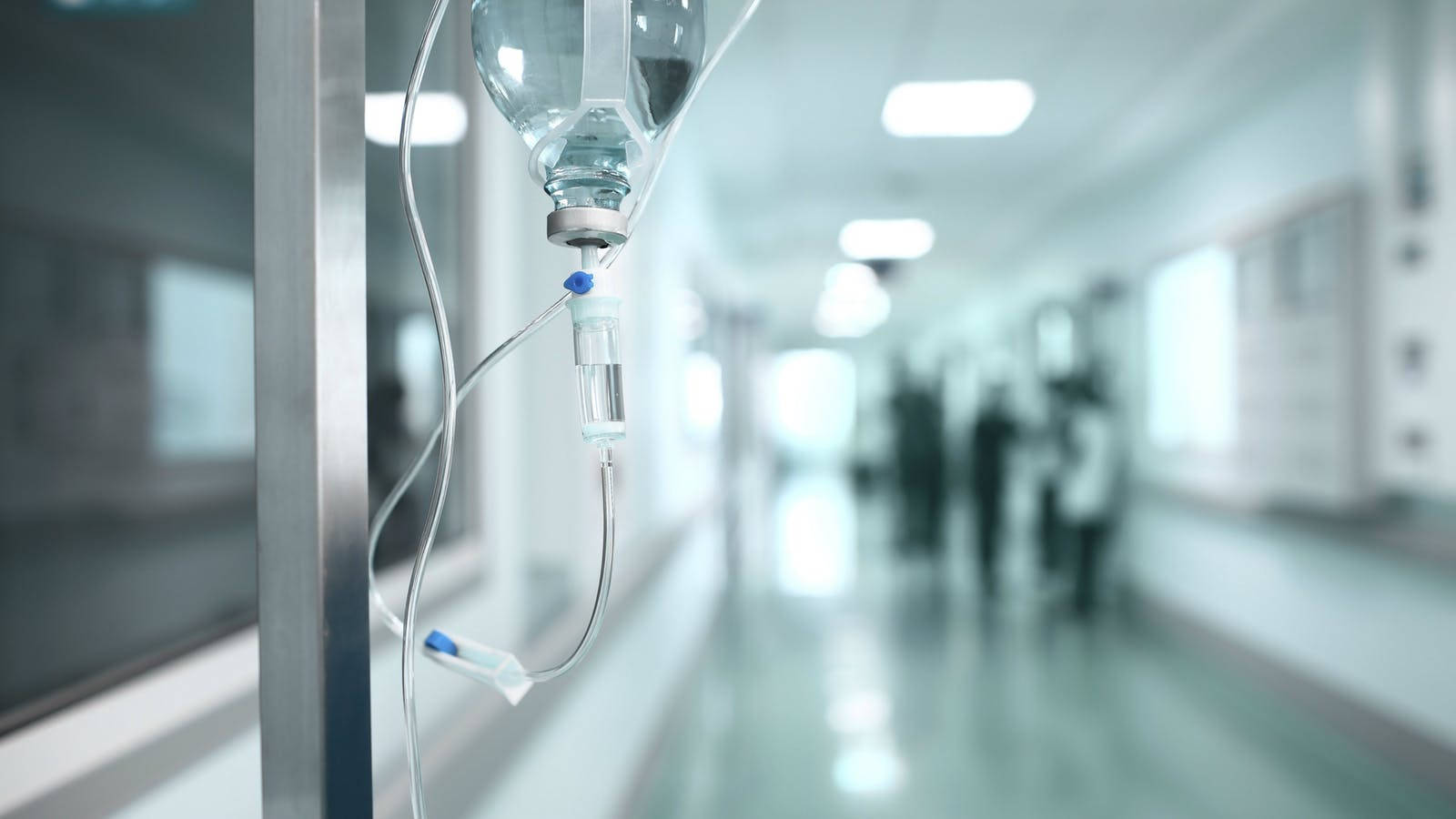 Intravenous Drip System In Hospital Hallway Background