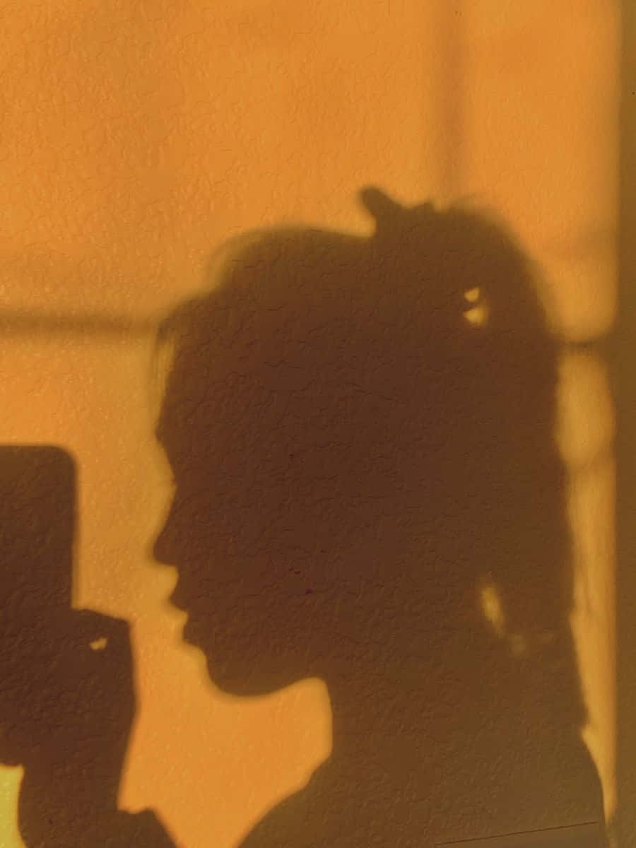 Intriguing Side Profile Of A Woman's Shadow Background