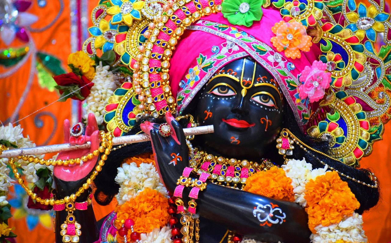 Iskcon Figure Of Krishna In Pink Turban Background