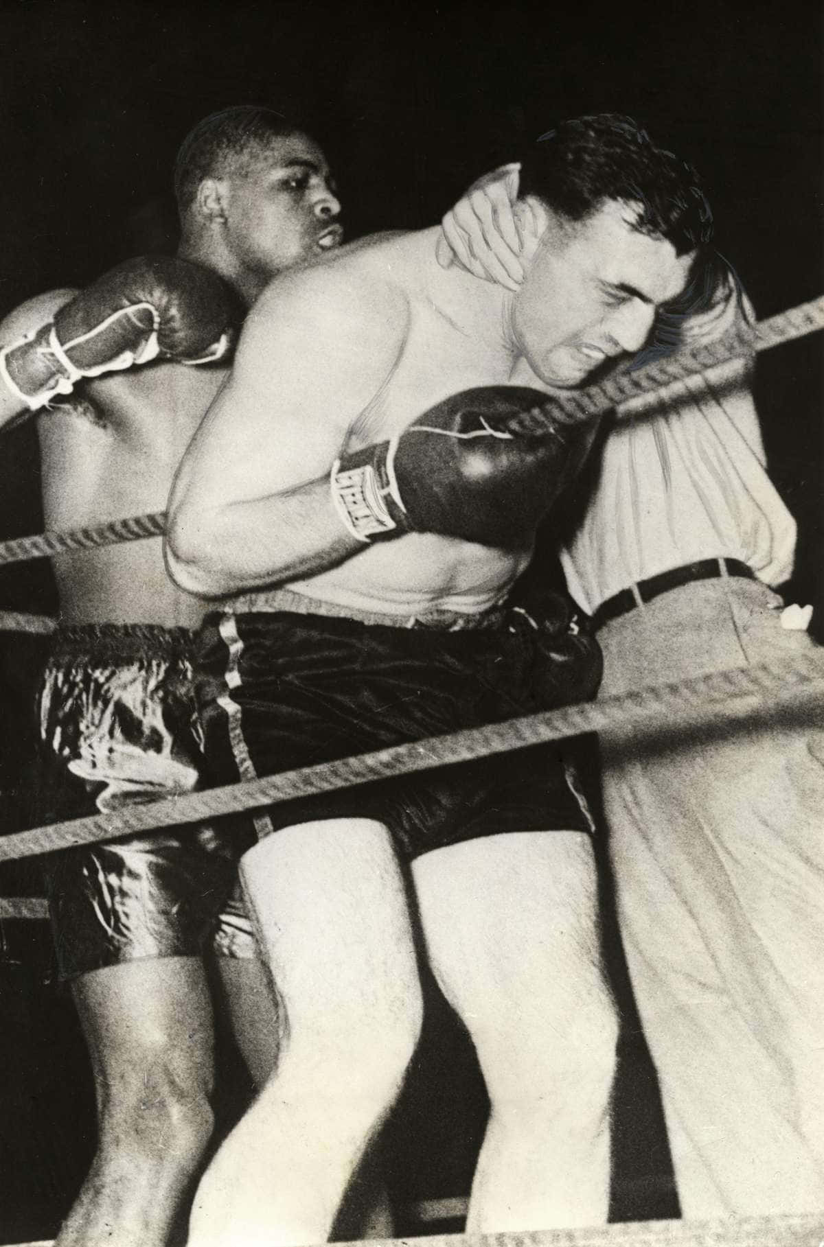 Italian Boxer Primo Carnera Holding On To The Ropes Background