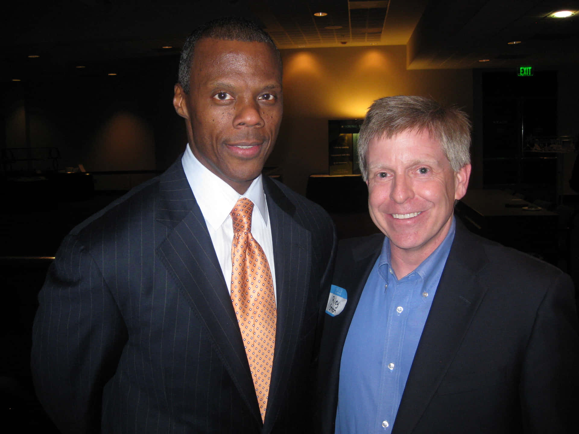 J.c. Watts And A Man In Suit Background