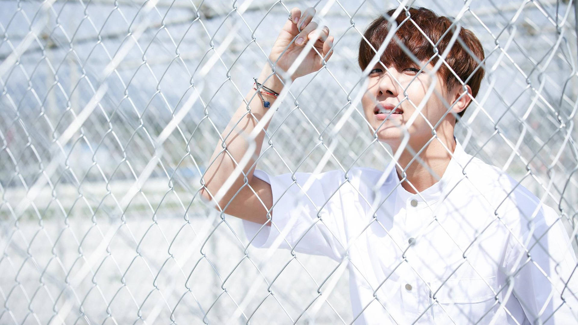 J-hope Holding On A Fence Background