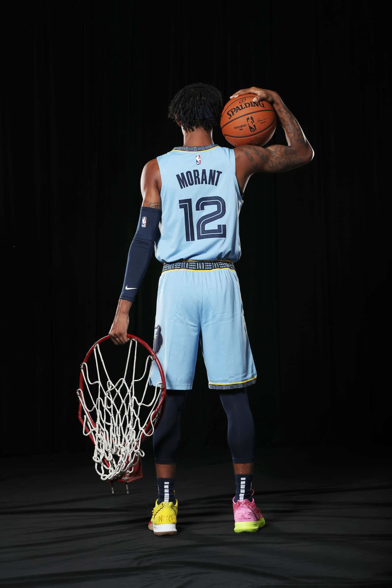 Ja Morrant Holding A Ball And A Ring Background