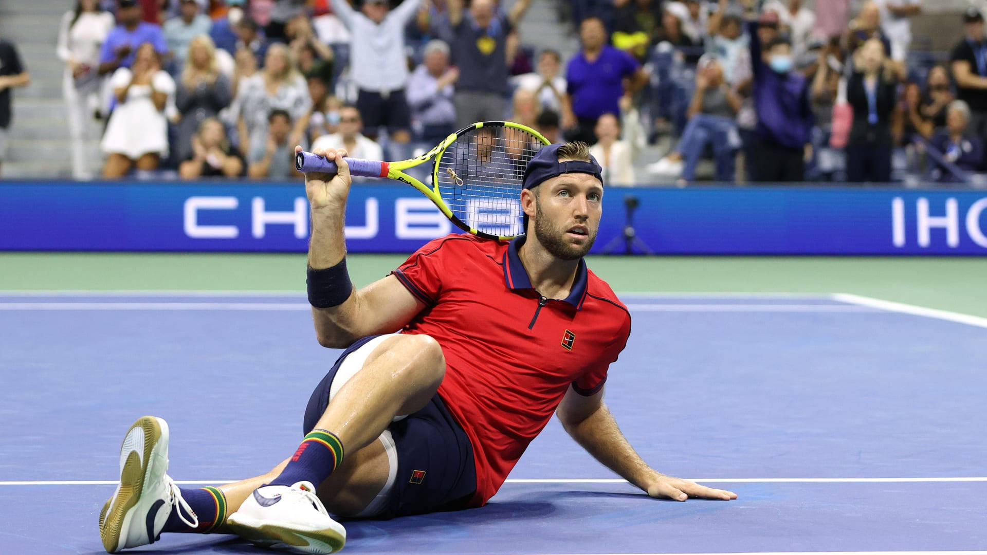 Jack Sock Sitting On Tennis Court Background