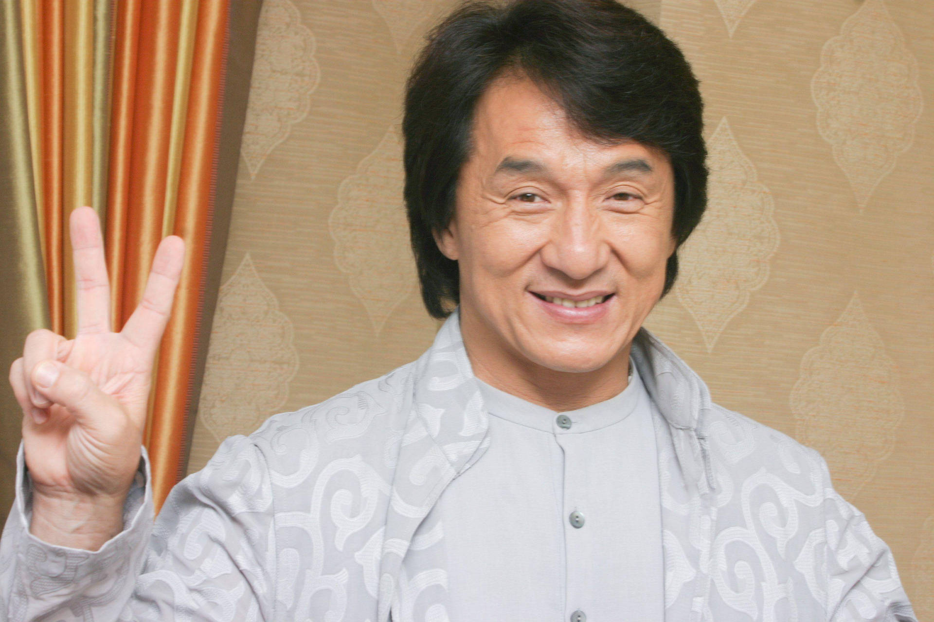 Jackie Chan Waving Peace Sign Background