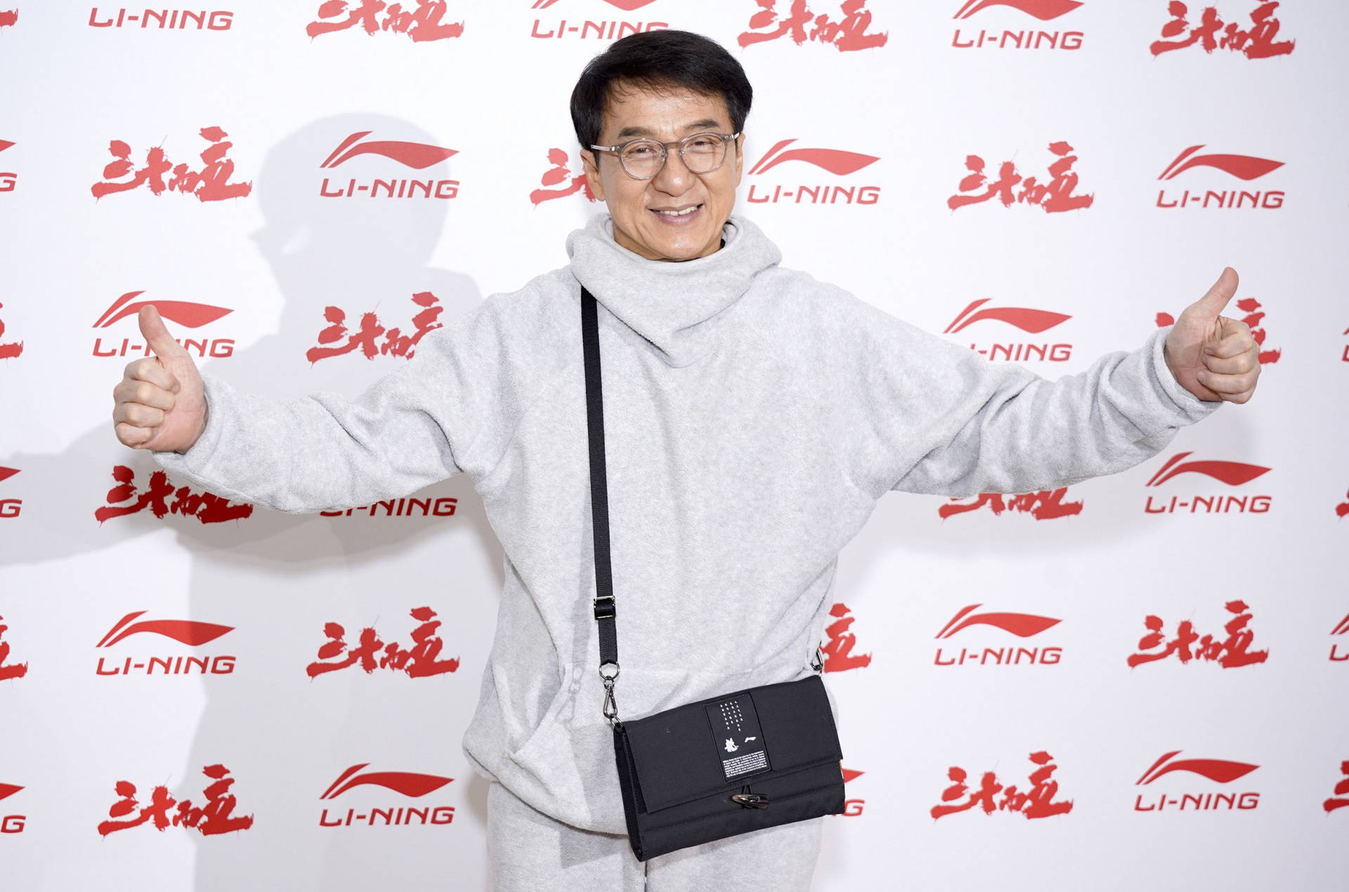 Jackie Chan Wearing A White Hoodie Background